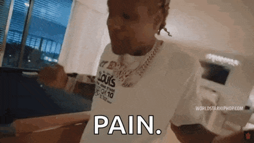 a man wearing a louis vuitton shirt is standing in a living room and says `` pain '' .