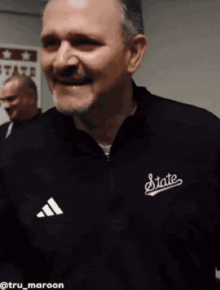 a man is wearing a black jacket with the word state on it