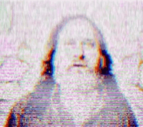 a blurry picture of jesus with long hair and a beard on a tv screen .