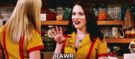 two women are standing next to each other in a diner talking to each other and one of them is saying rawr .