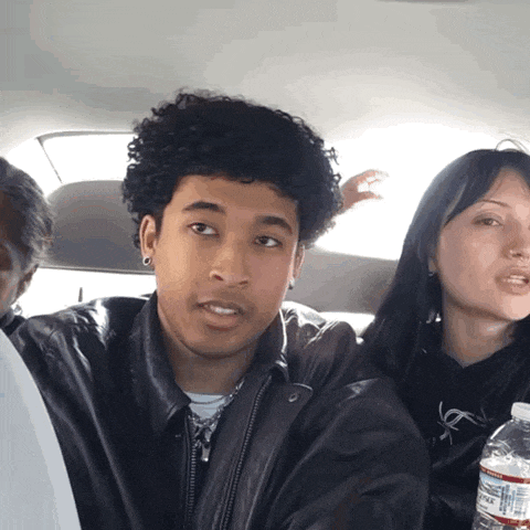 a man and a woman are sitting in a car with a bottle of water that says minute maid on it