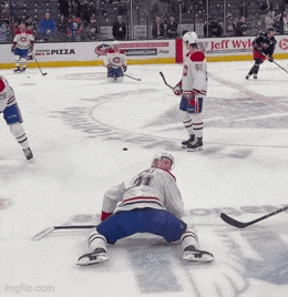 a hockey game is being played in front of an ad for jeff wylie pizza