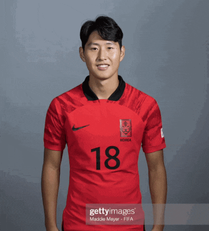 a man wearing a red korea jersey with the number 18 on it