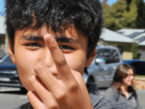 a young man is making a middle finger gesture in front of his face