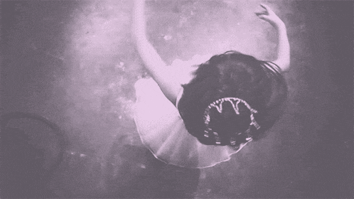 a black and white photo of a ballerina wearing a crown and a tutu .