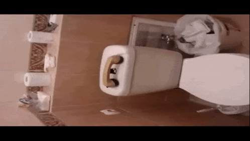 a toilet in a bathroom with a phone in the tank
