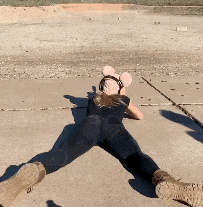 a woman wearing a pink hat and headphones laying on the ground