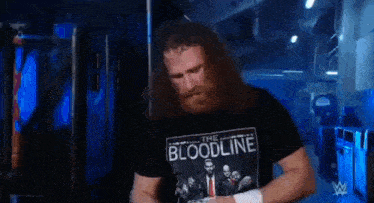 a man with a beard is wearing a t-shirt that says the bloodline on it .