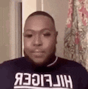 a man with a beard is wearing a tommy hilfiger sweater .