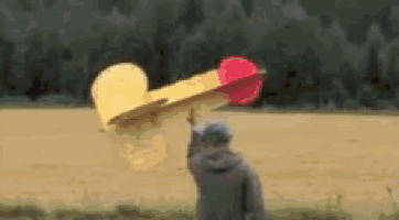 a man is standing in front of a yellow and red toy plane
