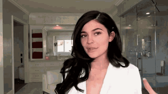 a woman in a white robe is in a bathroom