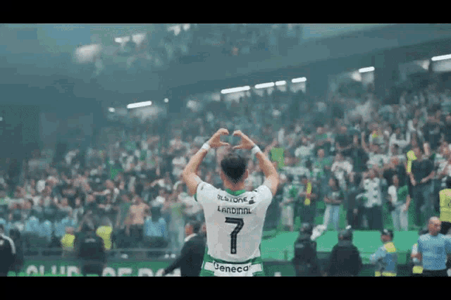 a soccer player with the number 7 on his jersey stands in front of a crowd