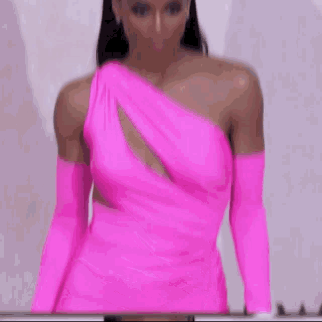 a woman wearing a bright pink one shoulder dress and gloves
