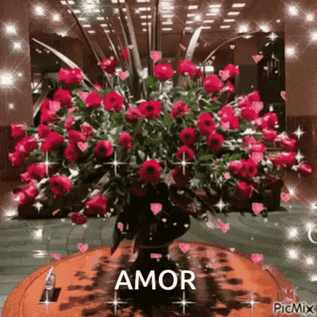 a bouquet of red roses in a vase with the word amor on the bottom