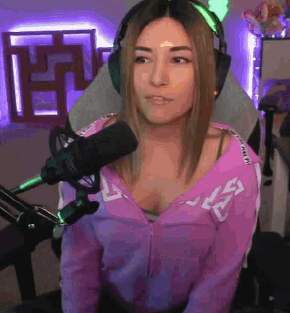 a woman wearing headphones and a pink jacket with the letter l on it