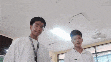 two boys are posing for a picture and one has a lanyard around his neck that says ' philippines ' on it
