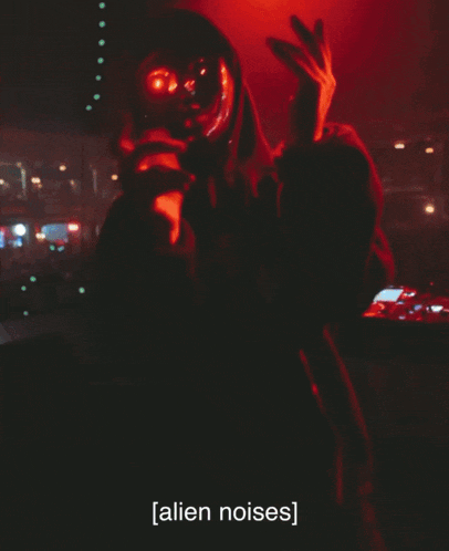 a man in a hooded jacket with red eyes says alien noises