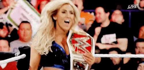 a woman in a wrestling ring holding a wwe championship