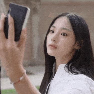 a woman taking a picture of herself with a cell phone