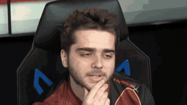 a man is sitting in a hyperx chair