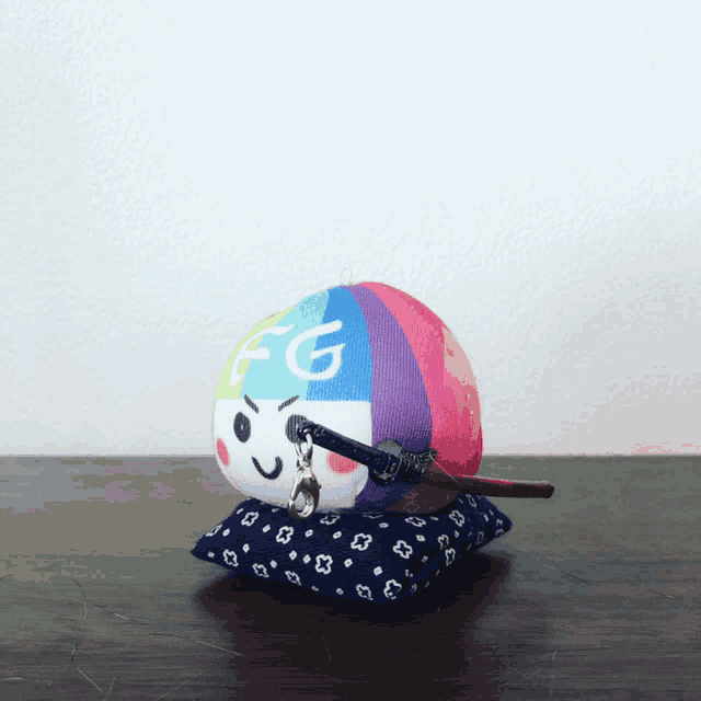 a stuffed toy with the letter g on it sits on a blue pillow