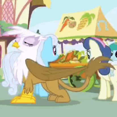 a couple of ponies are standing next to each other in front of a cart of fruits and vegetables .