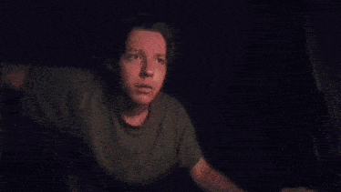 a man in a green t-shirt looks up at something