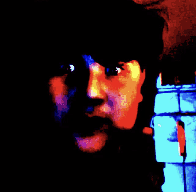 a close up of a person 's face with a blue and red background