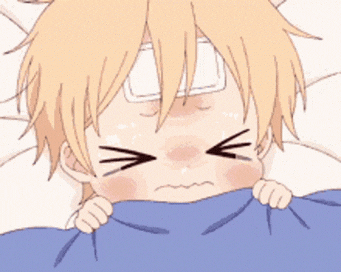 a baby with a bandage on his forehead is laying under a blanket and crying .