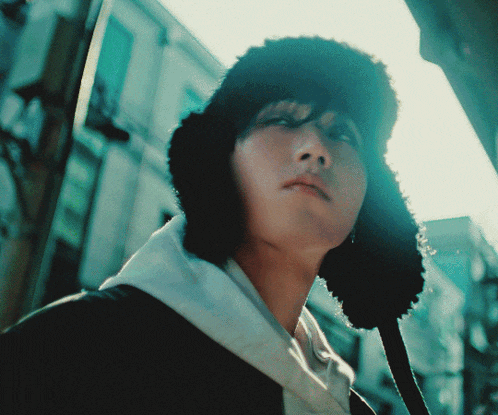 a close up of a person wearing a black furry hat