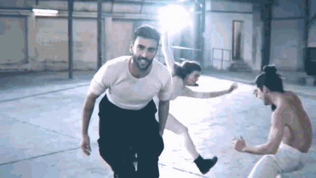 a man in a white shirt is dancing with a woman in white tights