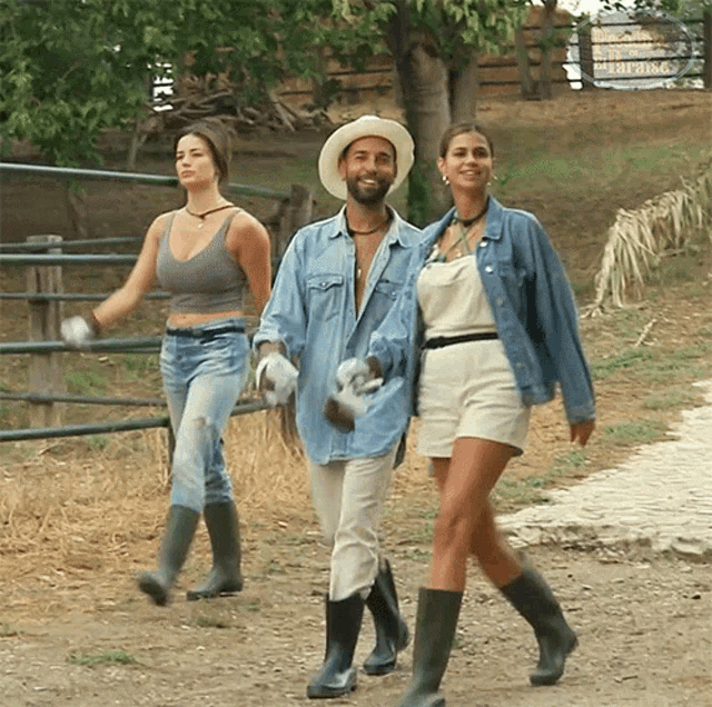 a man in a cowboy hat walking with two women