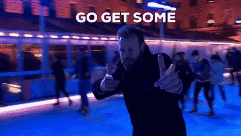 a man giving a thumbs up in front of a sign that says " go get some "