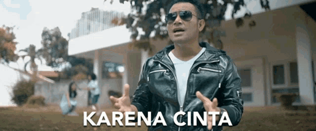 a man wearing sunglasses and a leather jacket is standing in front of a house with the words karena cinta written on the bottom