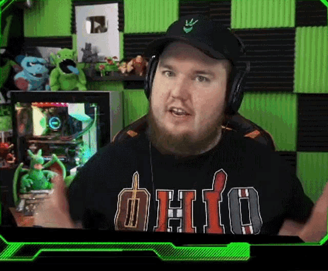 a man with a beard wearing headphones and a black shirt that says dhto on it