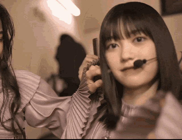 a girl with a microphone on her head is talking on a cell phone