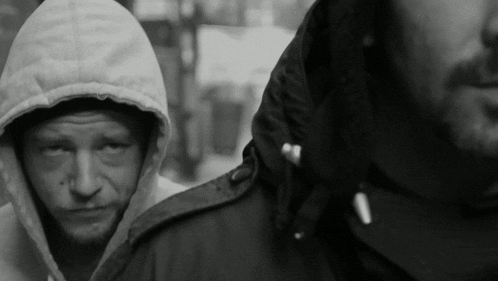 a man in a hooded jacket stands next to another man