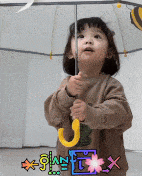 a little girl is holding a yellow umbrella with a sticker that says x