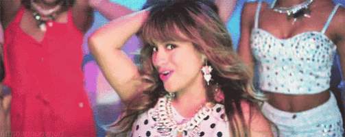 a woman in a polka dot dress is dancing with two other women in a video .
