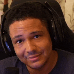 a man wearing headphones is sitting in a chair and smiling .