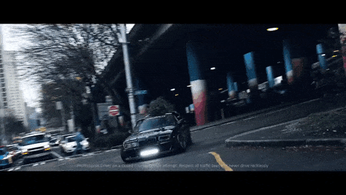 a car with a christmas tree on the back is driving down a city street
