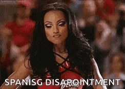 a cheerleader is standing in front of a crowd with the words `` spanish disappointment '' written next to her .