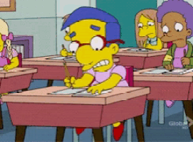 a cartoon character sits at a desk with a pencil