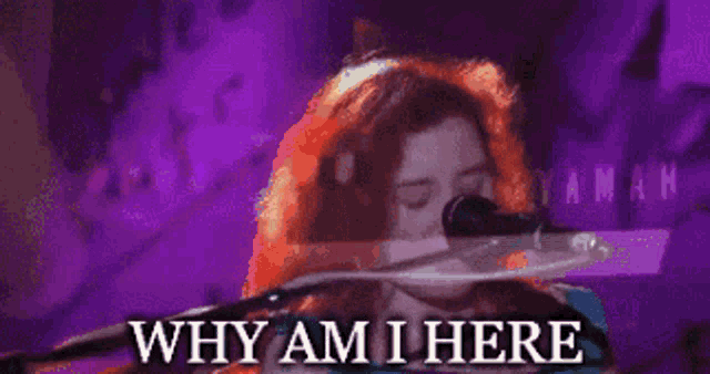 a woman singing into a microphone with the words " why am i here " above her