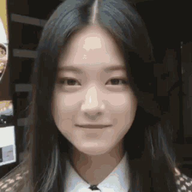 a close up of a woman 's face with long hair and a white shirt .