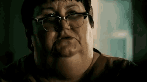 a close up of a woman wearing glasses making a funny face