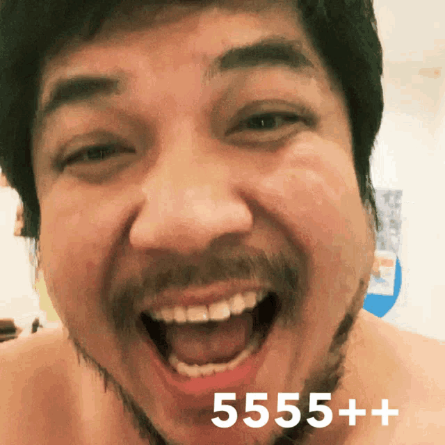 a man with a beard is smiling with the number 5555+ written on the bottom