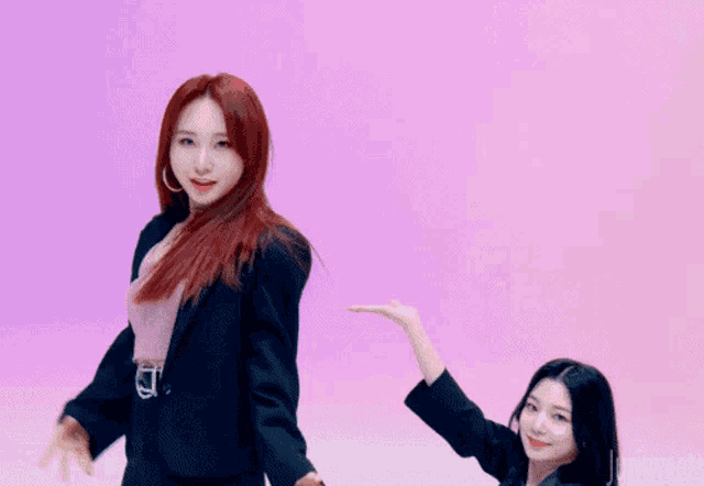 a woman with red hair winks at the camera while dancing