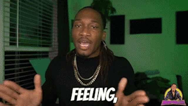 a man wearing a black shirt that says feeling on it