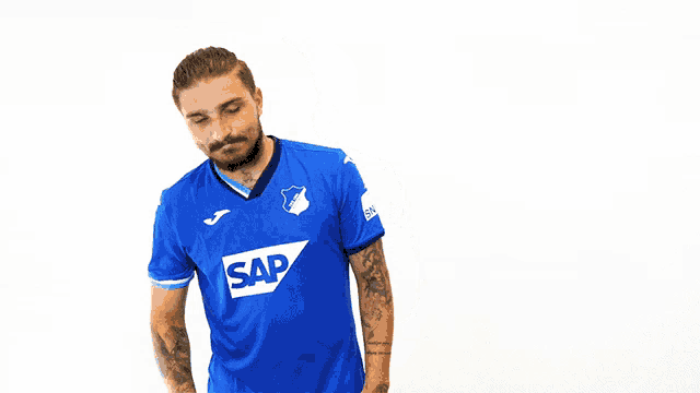 a man wearing a blue shirt with a tsg logo on it